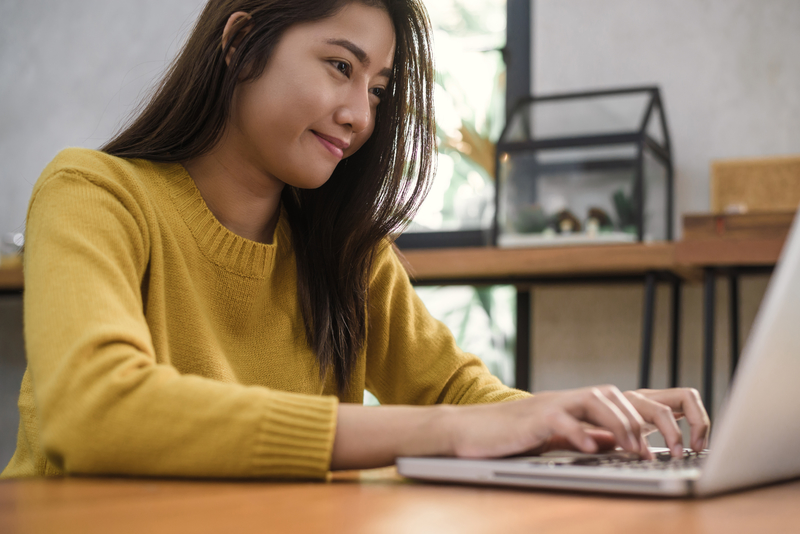 Young Asian woman working with the laptop on a desk